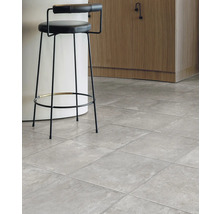 Innenraumansicht mit grauem Fliesenboden und Barhocker