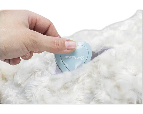 Hand, die ein herzförmiges Behältnis mit dem Beeztees Logo auf einem Fell platziert.