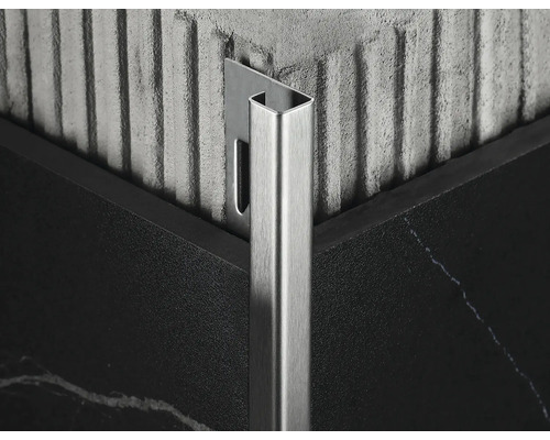 Detailaufnahme einer Fliesenschiene aus Metall an einer Ecke zwischen zwei Fliesen