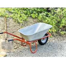 Schubkarre mit Metallewanne und Spaten im Garten