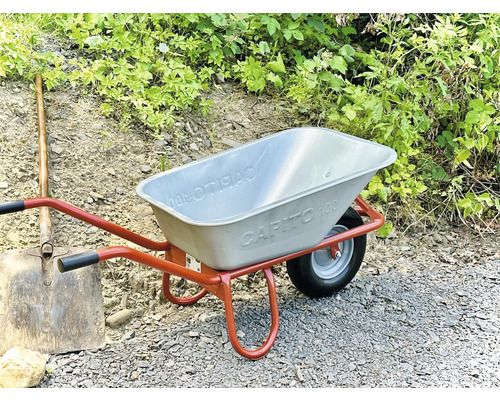 Schubkarre mit Metallewanne und Spaten im Garten