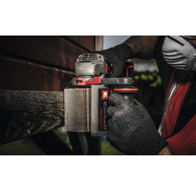 Akku-Multischleifer im Einsatz an einem Holzstück, bedient von einer Person mit Handschuhen und Einhell Logo.