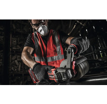 Ein Mann mit Schutzbrille, Atemschutzmaske, Warnweste und Handschuhen arbeitet mit einer Einhell Akku-Blechschere an einem Metallrohr.