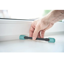 Une personne utilise une cale de fenêtre pour ouvrir une fenêtre.