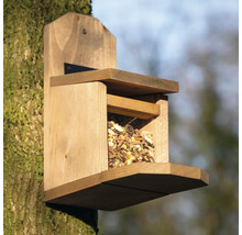 Vogelhaus aus Holz mit Futter gefüllt an einem Baum befestigt