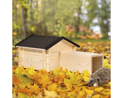 Igelhaus aus Holz mit Igel im Herbstlaub