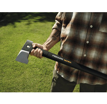 Personne tenant une hache à fendre Fiskars Ultra sur fond vert