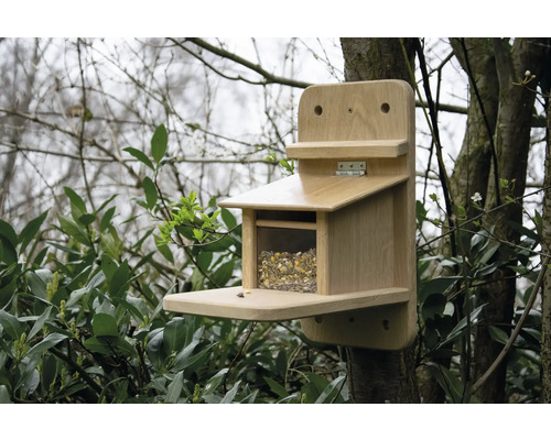 Holzvogelhaus mit Futter an einem Baum befestigt