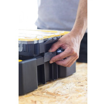 Une main ouvre une boîte à outils sur une table en bois