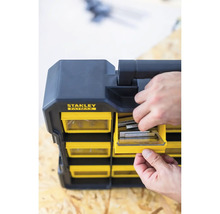 Boîte de rangement Stanley Fatmax avec une main plaçant des agrafes dans un compartiment.
