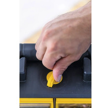 Main actionnant la fermeture jaune sur la boîte à outils