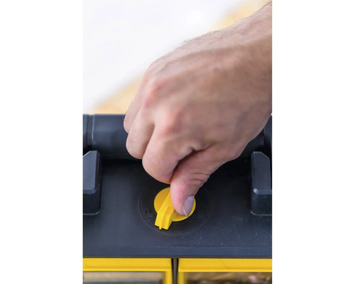 Main actionnant la fermeture jaune sur la boîte à outils