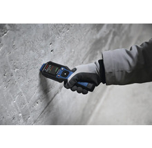 Main avec humidimètre Bosch sur un mur en béton
