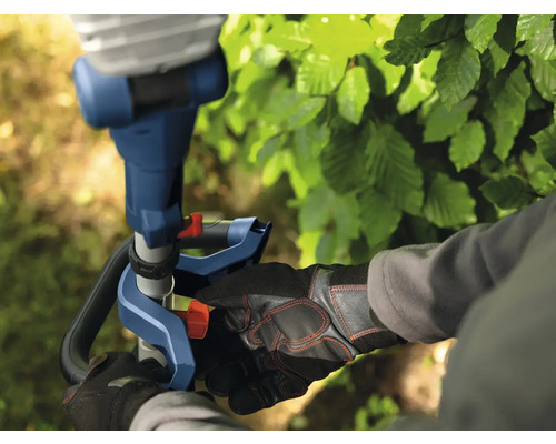 Gros plan d'une personne travaillant avec un taille-haie, mettant l'accent sur le fonctionnement et l'équipement de sécurité.