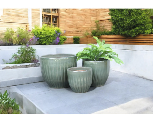Drei Pflanzgefäße aus Keramik auf einer Terrasse