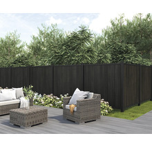 Gartenszene mit dunklem Sichtschutzzaun und Sitzgruppe auf einer Terrasse