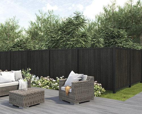 Gartenszene mit dunklem Sichtschutzzaun und Sitzgruppe auf einer Terrasse