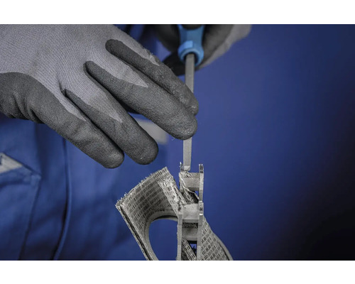 Une personne travaille une pièce à l'aide d'une lime tout en portant des gants de protection.