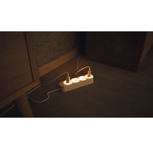 Steckdosenleiste mit angeschlossenen Geräten auf dem Boden