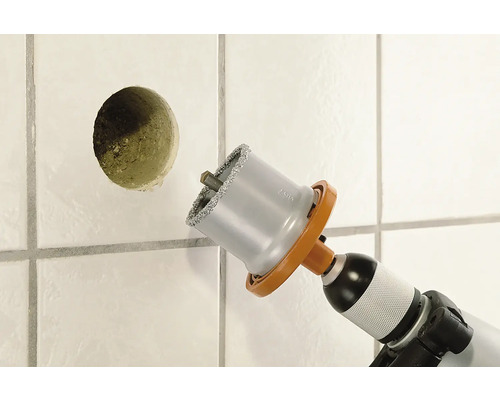 Perceuse à carrelage perçant un trou dans un mur carrelé