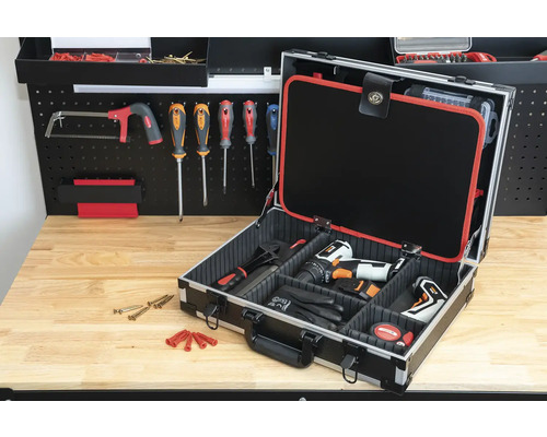 Offener Werkzeugkoffer mit Werkzeugen auf einer Werkbank