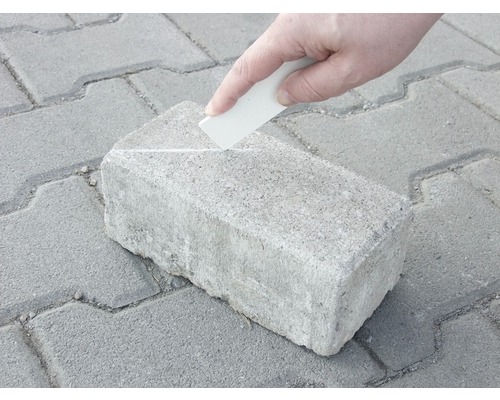 Une personne marque un pavé avec un marqueur.