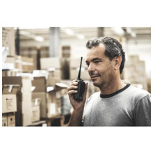 Ein Mann benutzt ein Funkgerät in einem Lagerhaus.