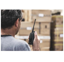 Eine Person hält ein Funkgerät in der Hand.