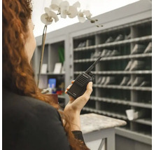 Frau hält ein Funkgerät der Marke Midland in der Hand