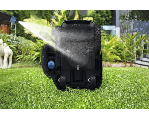 Reinigung eines Rasenmähroboters mit Wasserstrahl auf einer Rasenfläche