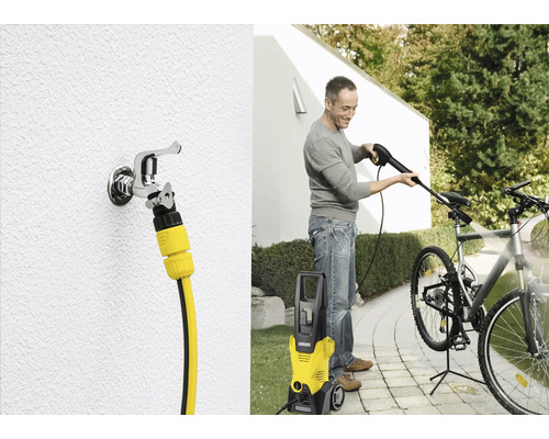 Un homme nettoie un vélo avec un nettoyeur haute pression Kärcher. On peut également voir un robinet avec un raccord de tuyau.