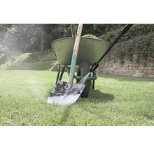 Nettoyage d'une pelle avec un nettoyeur haute pression à côté d'une brouette dans le jardin