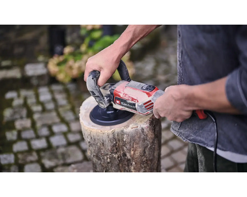 Mann schleift Holzscheit mit einem Einhell Schleifer.