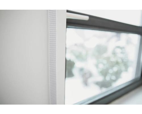 Detailansicht eines weißen Rollos neben einem Fenster