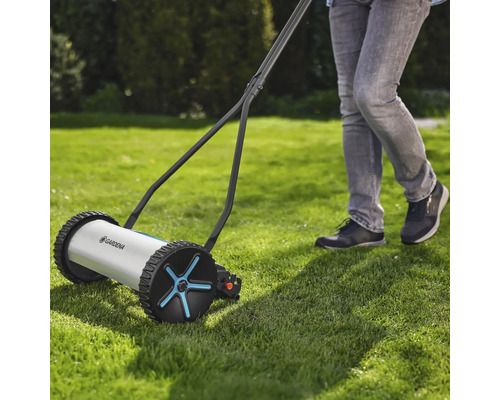 Tondeuse à gazon manuelle en cours d'utilisation sur une pelouse