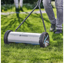 Tondeuse à gazon manuelle en fonctionnement sur une pelouse avec le logo Gardena
