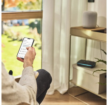 Eine Person bedient eine Gartenbewässerungs-App auf einem Smartphone