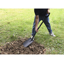 Eine Person gräbt mit einem Spaten im Garten.