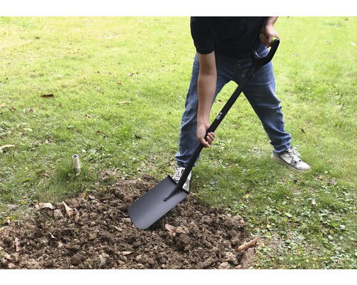 Eine Person gräbt mit einem Spaten im Garten.