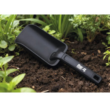 Gartenschaufel im Beet mit for_q Logo auf dem Griff