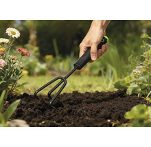 Gartenharke im Einsatz in einem Gartenbeet