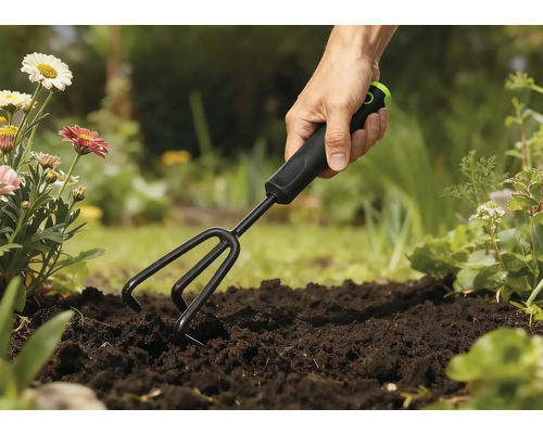Gartenharke im Einsatz in einem Gartenbeet