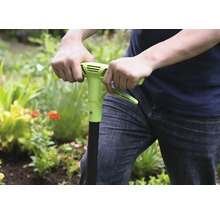 Personne utilisant un désherbeur dans le jardin.
