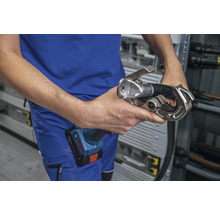 Eine Person hält eine Crimpzange für Kabelverschraubungen.