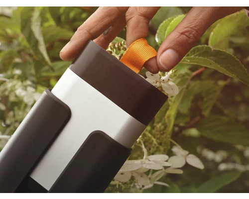 Une personne tire sur une bande orange sur un outil de jardinage.