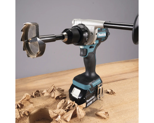 Perceuse sans fil avec mèche à bois et copeaux sur surface en bois