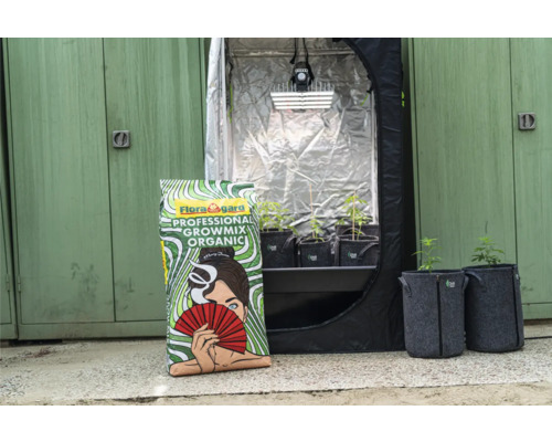 Flora Gard Professional Growmix Organic à côté de la tente de culture et des plantes