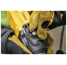 Gros plan d'une personne utilisant une meuleuse d'angle avec des gants de protection