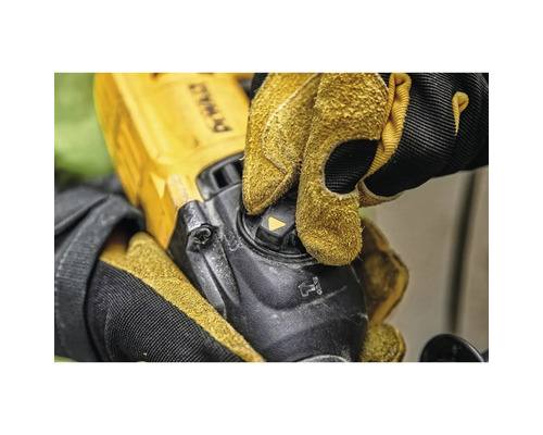 Gros plan d'une personne utilisant une meuleuse d'angle avec des gants de protection