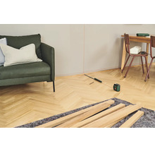 Vue d'une pièce avec un laser de nivellement, des lattes de bois et des meubles pour des travaux de rénovation